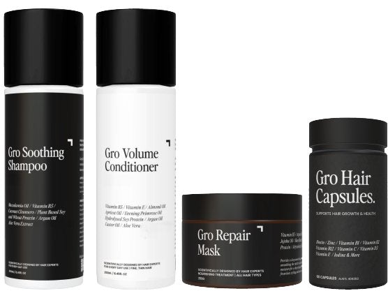 Four hair care products from the Ultimate Pack - Volume by Gro Clinics are displayed. From left to right: Soothing Shampoo, Volume Conditioner, Hair Repair Mask in a jar, and Hair Capsules in a bottle. The bottles and jar are white and black with minimalist labeling, perfect for those seeking solutions for thinning hair.